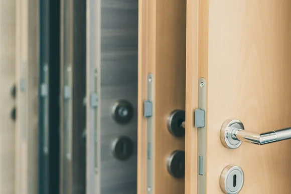 Nahaufnahme von mehreren Holztüren mit Türgriffen.